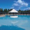 Piscina all'aperto con una struttura bianca centrale e sky blu.