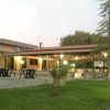 Esterno di un ristorante con tavoli all'aperto e giardino.