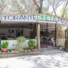 Ristorante con terrazza all'aperto tra gli alberi.