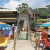 Area spiaggia con sedie a sdraio gialle, parasole colorati e cartello 